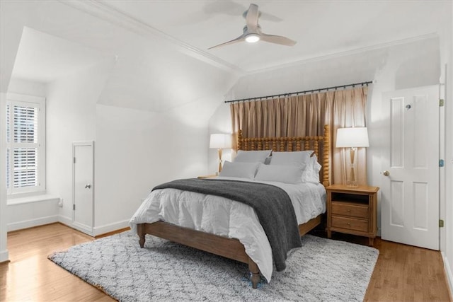 bedroom with ceiling fan, baseboards, wood finished floors, and crown molding
