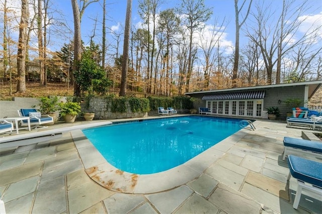 pool featuring french doors, a patio, and a diving board