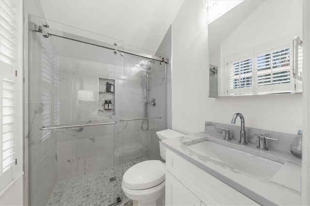 bathroom featuring a marble finish shower, toilet, and vanity