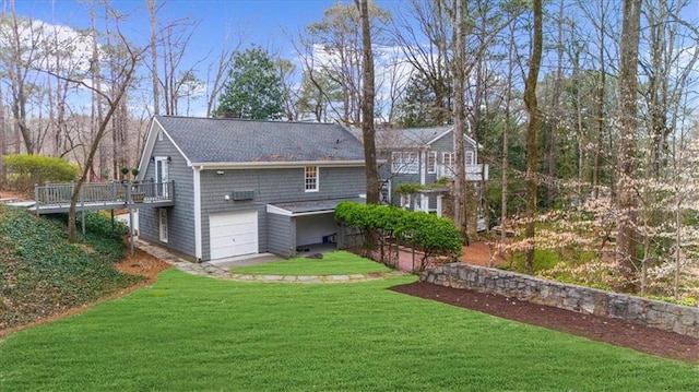 rear view of house with a lawn, an attached garage, and a wooden deck