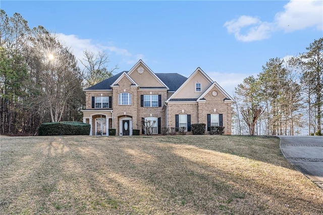 traditional home featuring brick siding and a front lawn