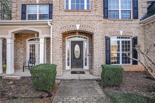 view of exterior entry featuring brick siding