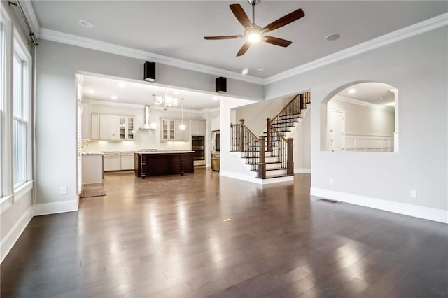 unfurnished living room with dark hardwood / wood-style floors, ceiling fan, ornamental molding, and sink