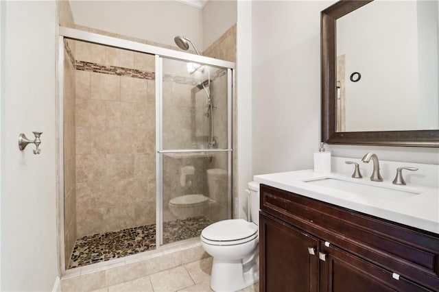 bathroom with tile patterned floors, a shower with door, vanity, and toilet