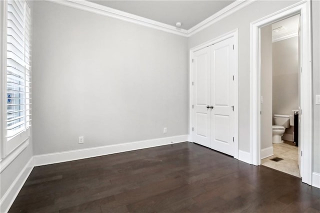 unfurnished bedroom with ensuite bath, crown molding, and dark hardwood / wood-style floors