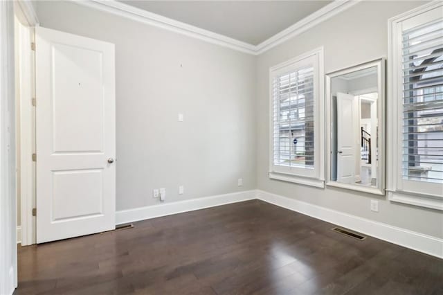 spare room featuring dark hardwood / wood-style flooring and crown molding