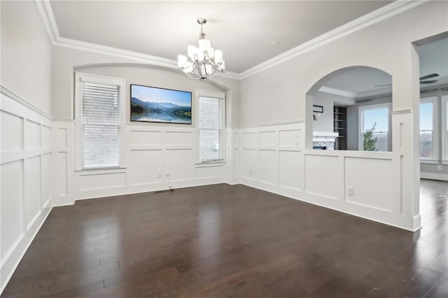 unfurnished dining area with dark hardwood / wood-style floors, an inviting chandelier, and ornamental molding