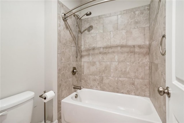 bathroom with tiled shower / bath combo and toilet