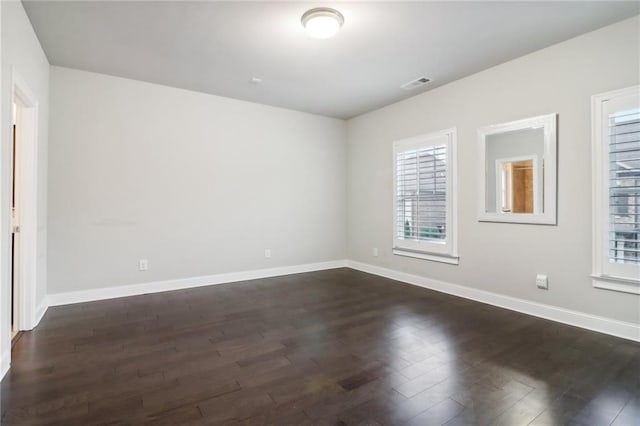 spare room with dark wood-type flooring