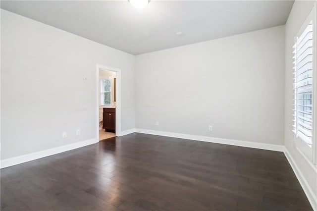 spare room featuring a wealth of natural light and dark hardwood / wood-style flooring