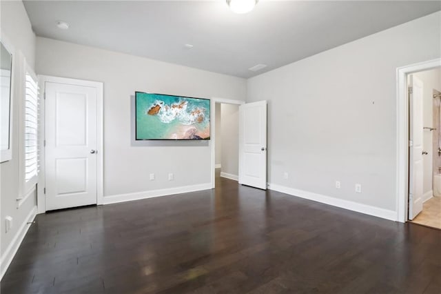 unfurnished bedroom with dark hardwood / wood-style floors and ensuite bath