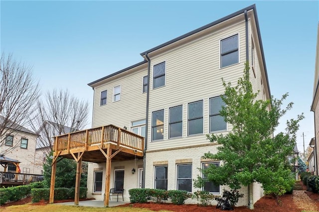 back of property with a patio and a wooden deck