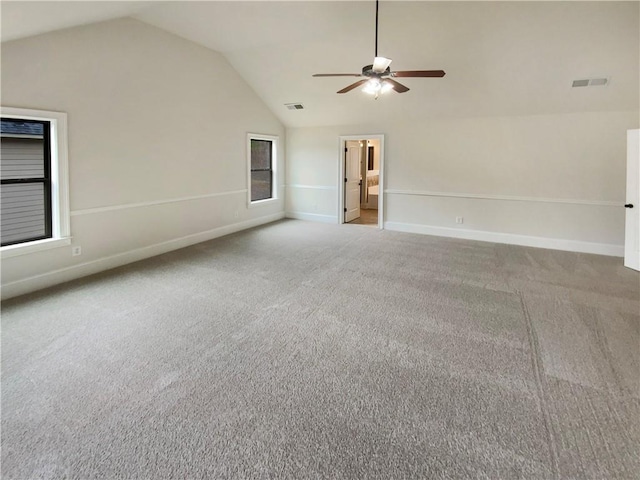 carpeted spare room with a ceiling fan, lofted ceiling, baseboards, and visible vents