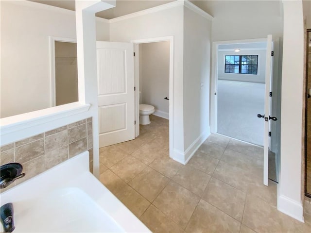 bathroom featuring tile patterned floors, baseboards, toilet, and ornamental molding