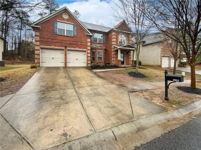 traditional-style house with brick siding, driveway, and a garage