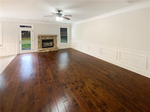 unfurnished living room with dark wood-type flooring, crown molding, a fireplace, and ceiling fan