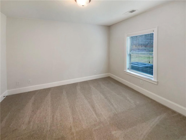 carpeted empty room featuring visible vents and baseboards