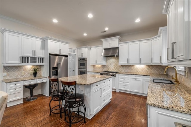 kitchen with under cabinet range hood, white cabinetry, appliances with stainless steel finishes, and a sink