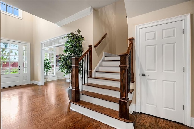 entryway featuring crown molding, stairway, wood finished floors, and baseboards