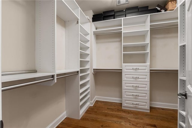 walk in closet with dark wood finished floors and visible vents