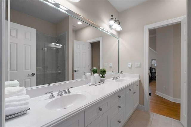 full bathroom featuring tile patterned flooring, a shower stall, double vanity, and a sink