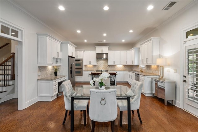 dining area with crown molding, stairway, visible vents, and dark wood-style flooring