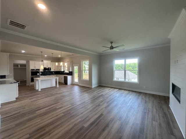 3799 Cheyenne Ln, Jefferson, GA 30549 - unfurnished living room with crown molding, baseboards, dark wood-style floors, ceiling fan, and a fireplace