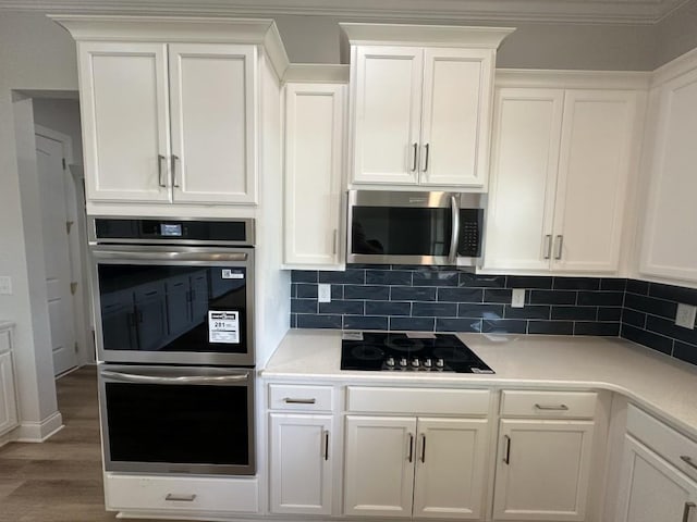 3799 Cheyenne Ln, Jefferson, GA 30549 - kitchen with stainless steel appliances, white cabinets, tasteful backsplash, light countertops, and ornamental molding