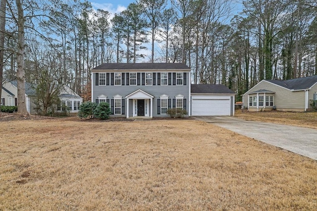 colonial home featuring a garage and a front lawn