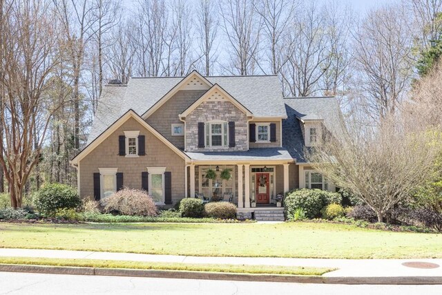 547 Sterling Water Dr, Monroe, GA 30655 - craftsman house with covered porch, a front lawn, stone siding, and a shingled roof
