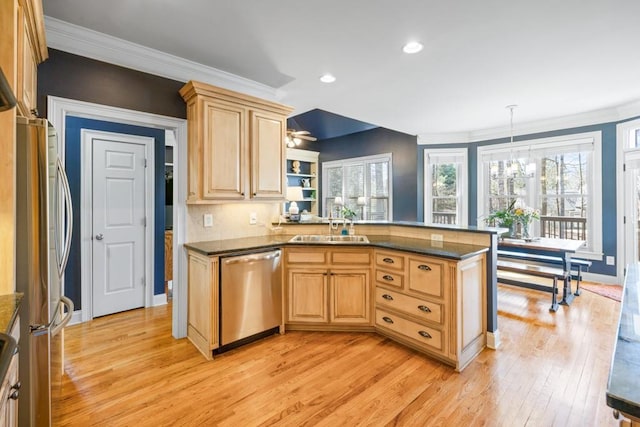 kitchen featuring light brown cabinets, a sink, appliances with stainless steel finishes, light wood-style floors, and crown molding