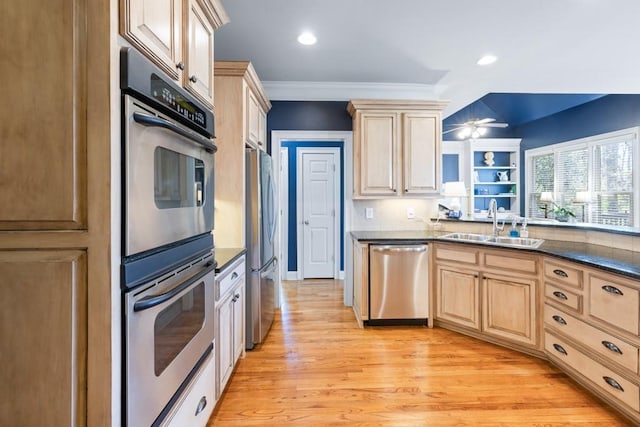 kitchen featuring a sink, light wood-type flooring, appliances with stainless steel finishes, and light brown cabinetry