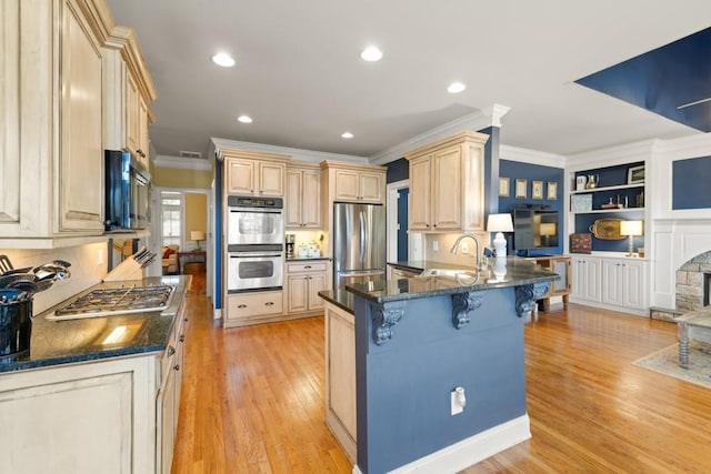 kitchen featuring a sink, ornamental molding, a kitchen bar, a peninsula, and stainless steel appliances