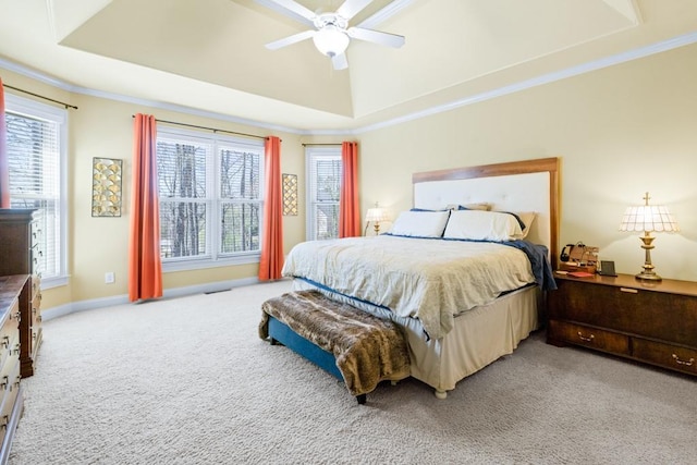 carpeted bedroom with visible vents, baseboards, ornamental molding, ceiling fan, and a tray ceiling