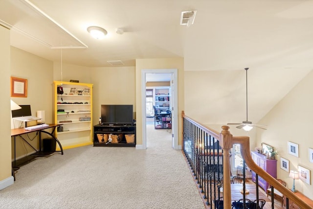interior space with visible vents, baseboards, an upstairs landing, carpet, and attic access