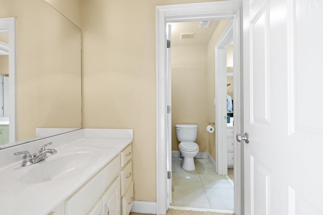 bathroom featuring vanity, visible vents, toilet, tile patterned floors, and baseboards