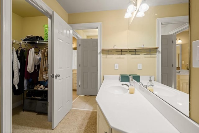 bathroom featuring a walk in closet and vanity