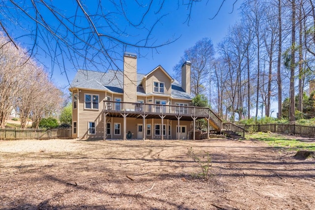 back of property featuring fence, stairway, a wooden deck, and a chimney