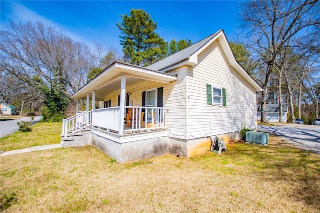 view of side of home featuring a yard and covered porch