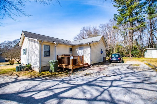 back of property featuring aphalt driveway and a deck