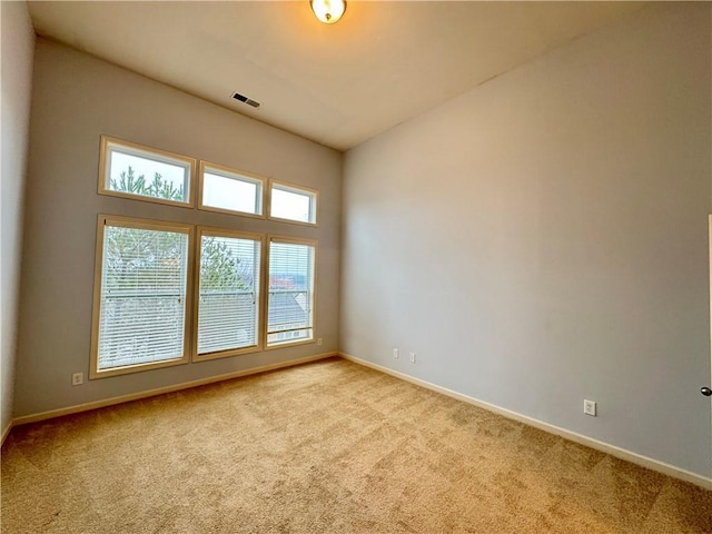 spare room featuring visible vents, baseboards, and carpet