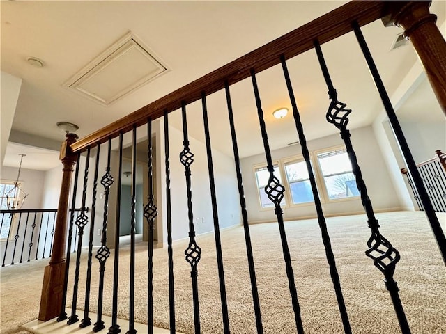 staircase with a wealth of natural light, baseboards, an inviting chandelier, and carpet floors