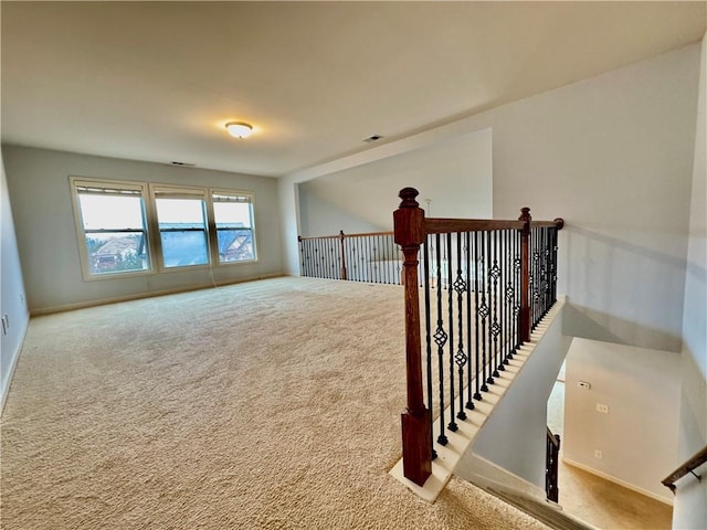 carpeted empty room featuring visible vents and baseboards