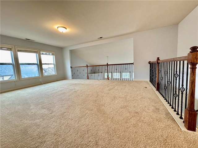 carpeted empty room with visible vents and baseboards