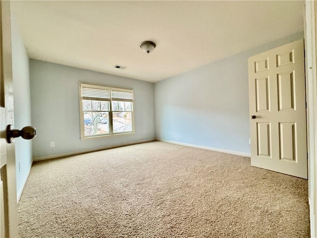 carpeted empty room featuring visible vents and baseboards