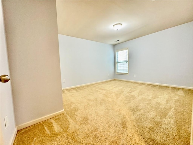 spare room featuring baseboards and carpet floors