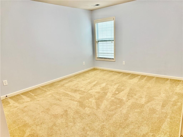 spare room featuring visible vents, baseboards, and carpet