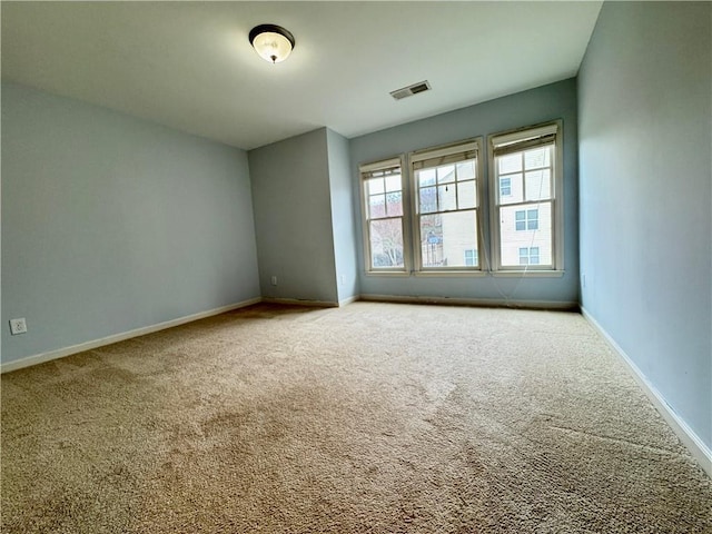 spare room with visible vents, baseboards, and carpet flooring