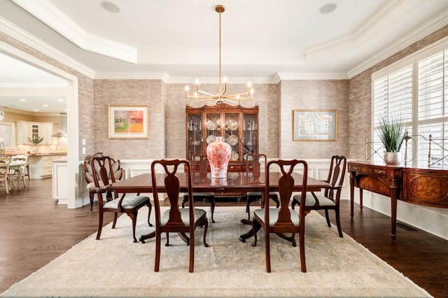 dining area with crown molding, an inviting chandelier, dark hardwood / wood-style flooring, and a tray ceiling