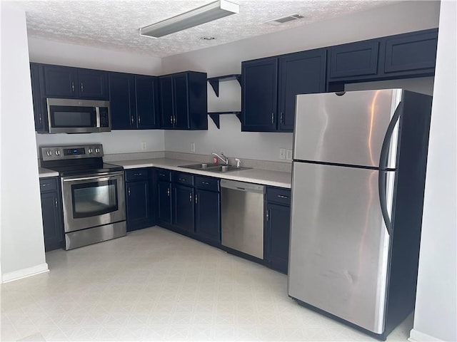 5425 Village Green Sq, Norcross, GA 30093 - kitchen with stainless steel appliances, blue cabinets, a textured ceiling, light countertops, and a sink